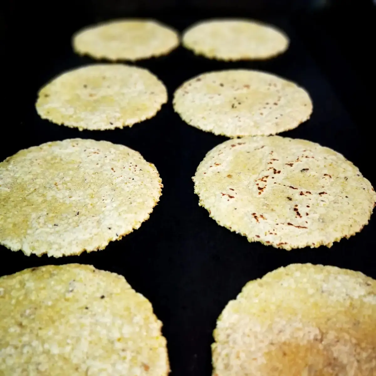 Fresh handmade tortillas cooking on a hot plate